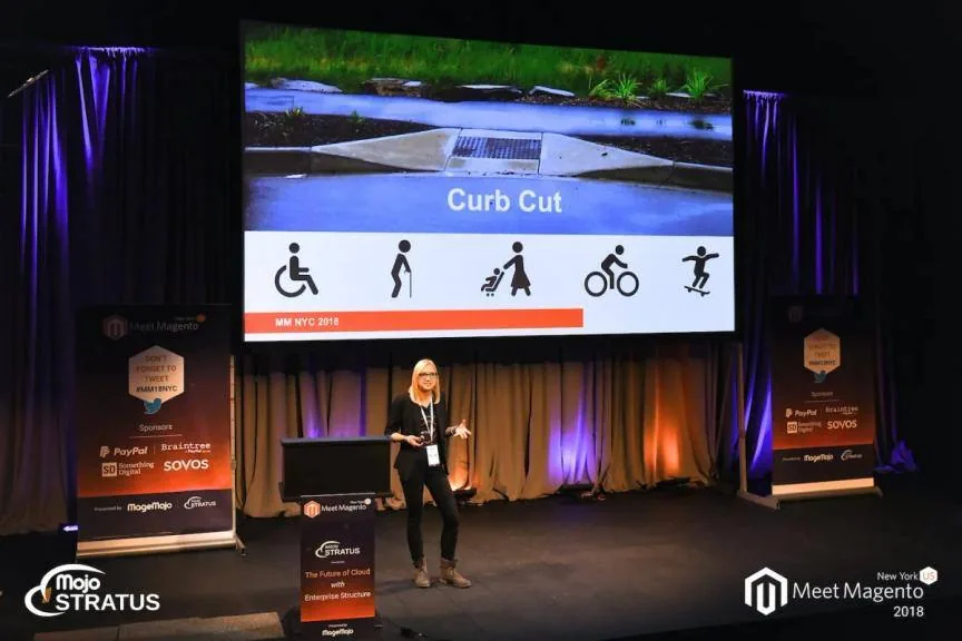 Speaker presenting a Curb Cut slide with icons for wheelchair users, walkers, parents with prams, cyclists and skateboarders