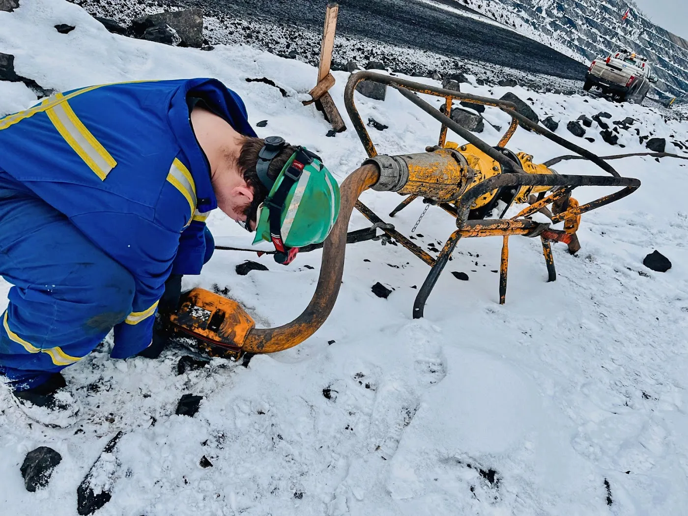 Mine worker checking an AcuSense node beside a cable coupler in the snow