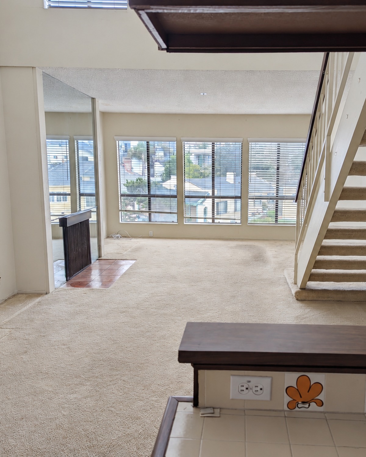 Living room before preparation, vacant with worn carpet