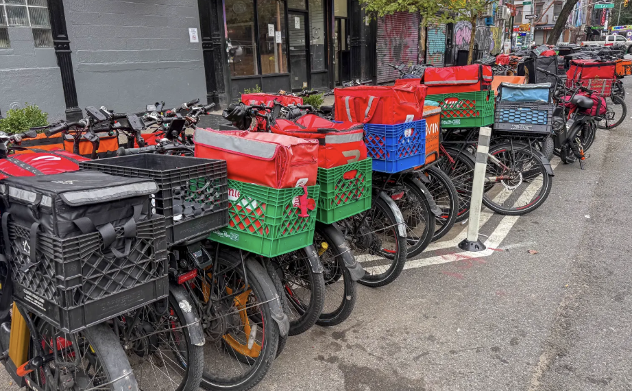 Delivery bicycles and delivery bags parked along an East Village street