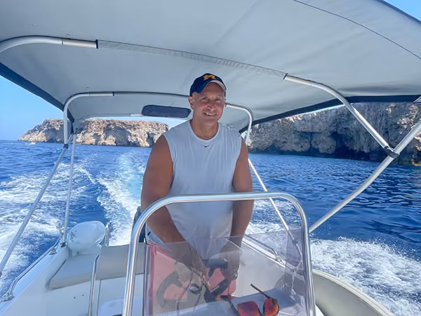 Patient smiling while driving a boat