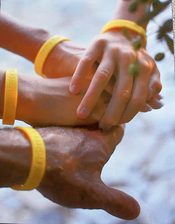 Hands embracing with yellow wristbands