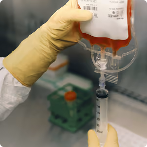 Gloved hands dispensing a sample in the lab