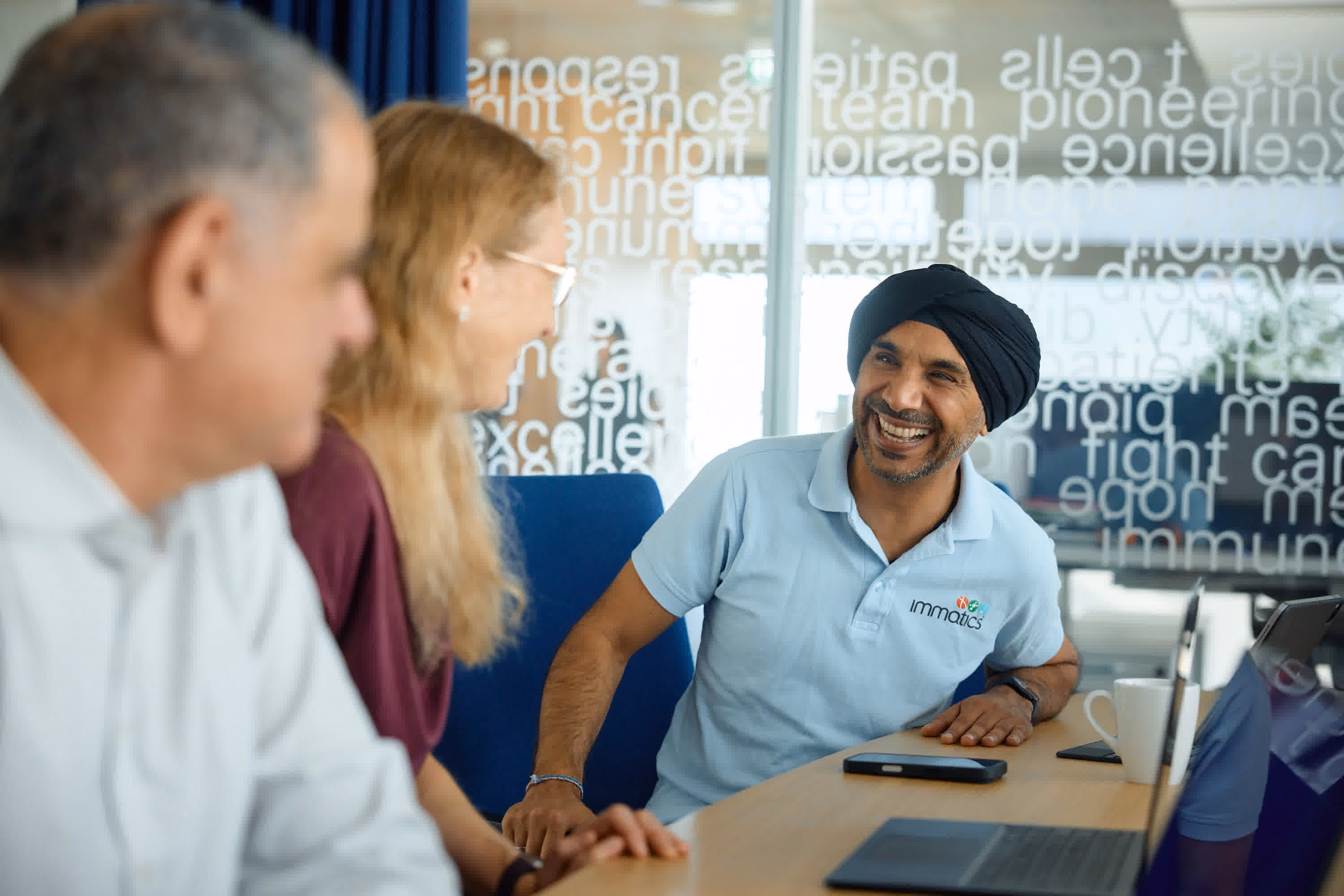 Immatics team members smiling in a conference room