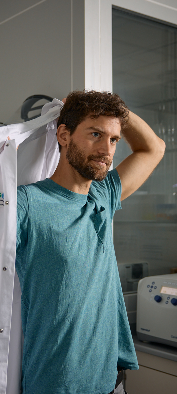 Scientist putting on white lab coat