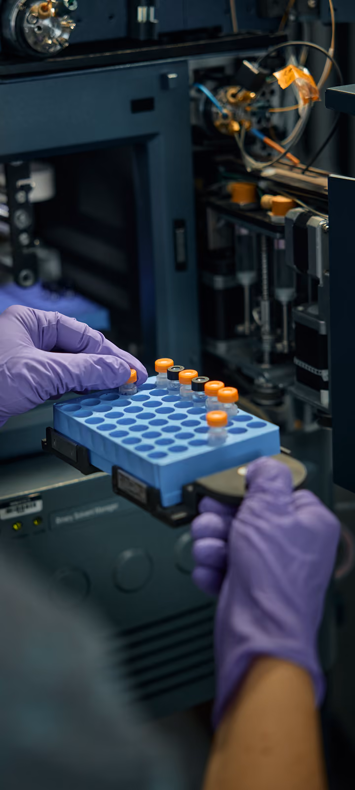 Gloved hands holding test tube samples in a lab