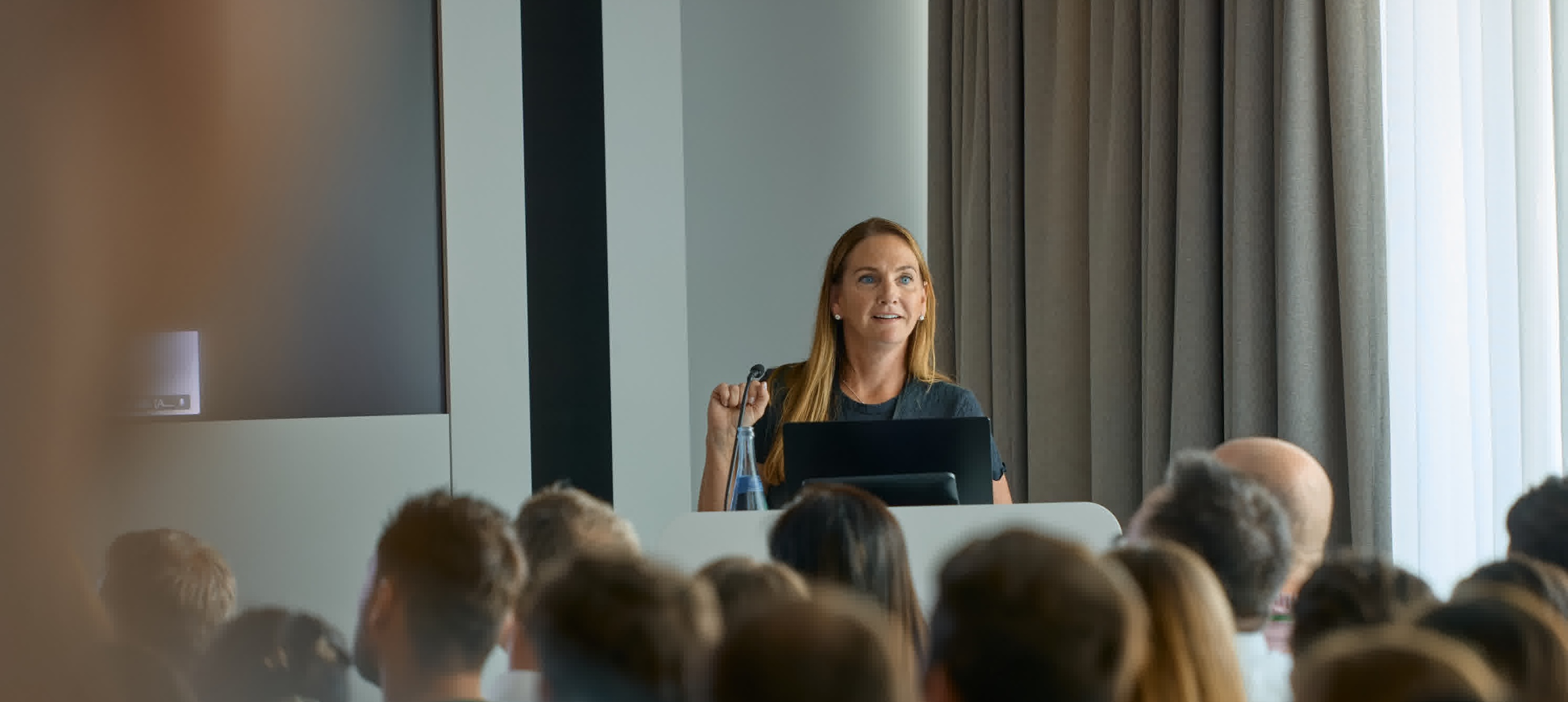 Woman at podium presenting at a press conference