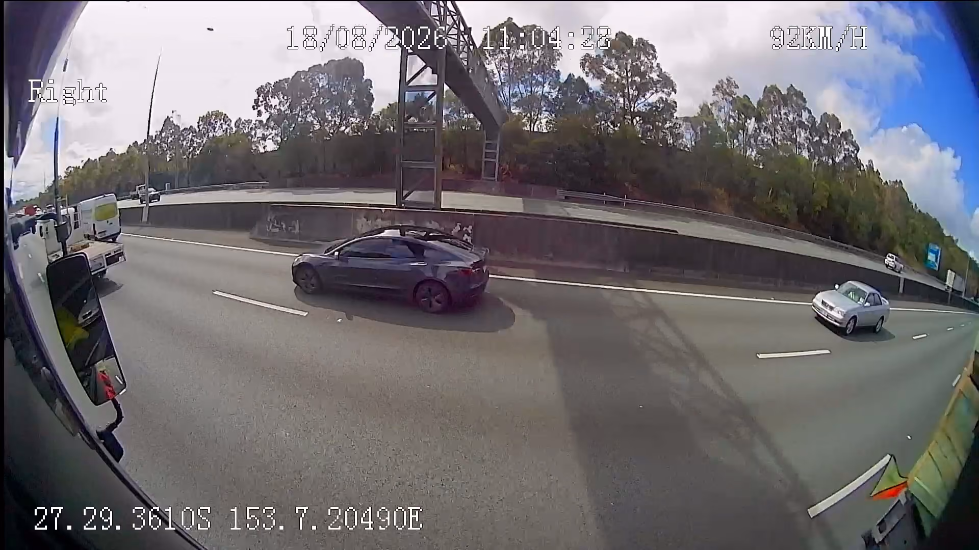Right-side camera view from a truck showing traffic in the adjacent motorway lane