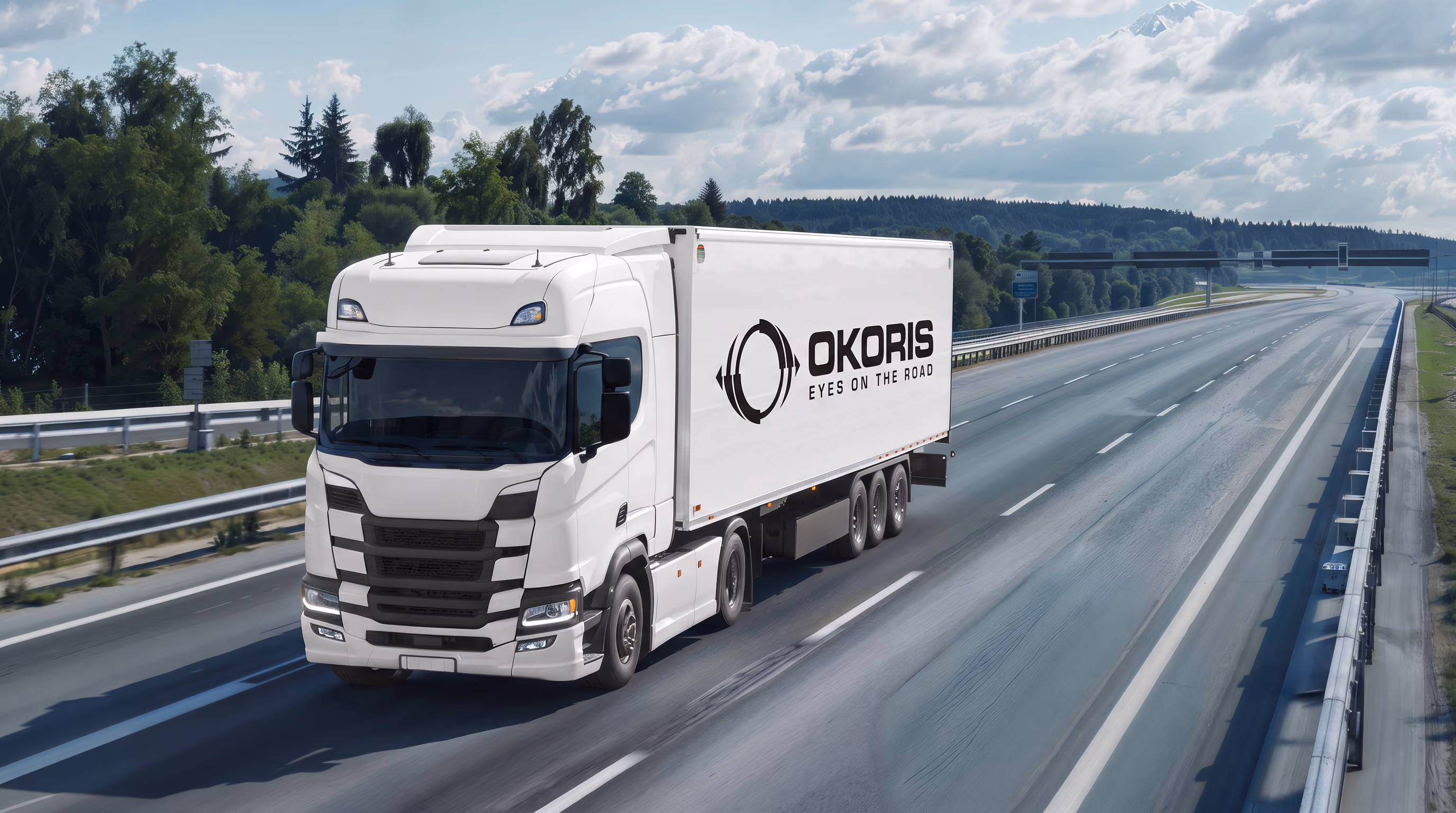 OKORIS-branded prime mover and trailer travelling along a divided highway
