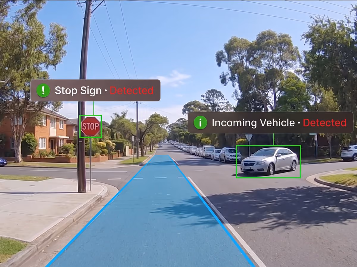 Forward-facing camera detecting a stop sign and an incoming vehicle at a suburban intersection