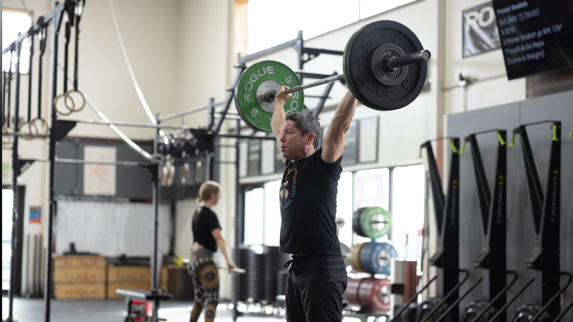 Man lifting a barbell overhead during a CrossFit Light class at Sundog CrossFit in Fairbanks, Alaska.