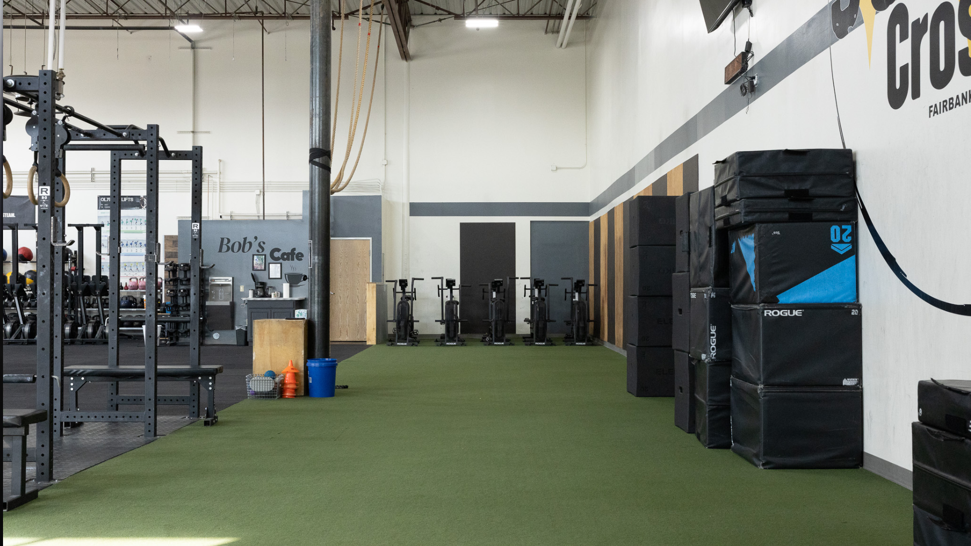 Indoor training area with turf, strength equipment, and plyometric boxes at Sundog CrossFit in Fairbanks, Alaska.
