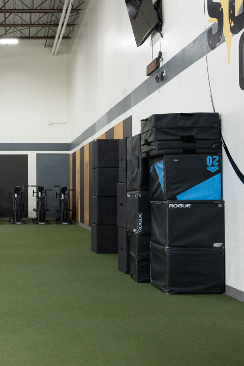 Indoor training area with turf, strength equipment, and plyometric boxes at Sundog CrossFit in Fairbanks, Alaska.