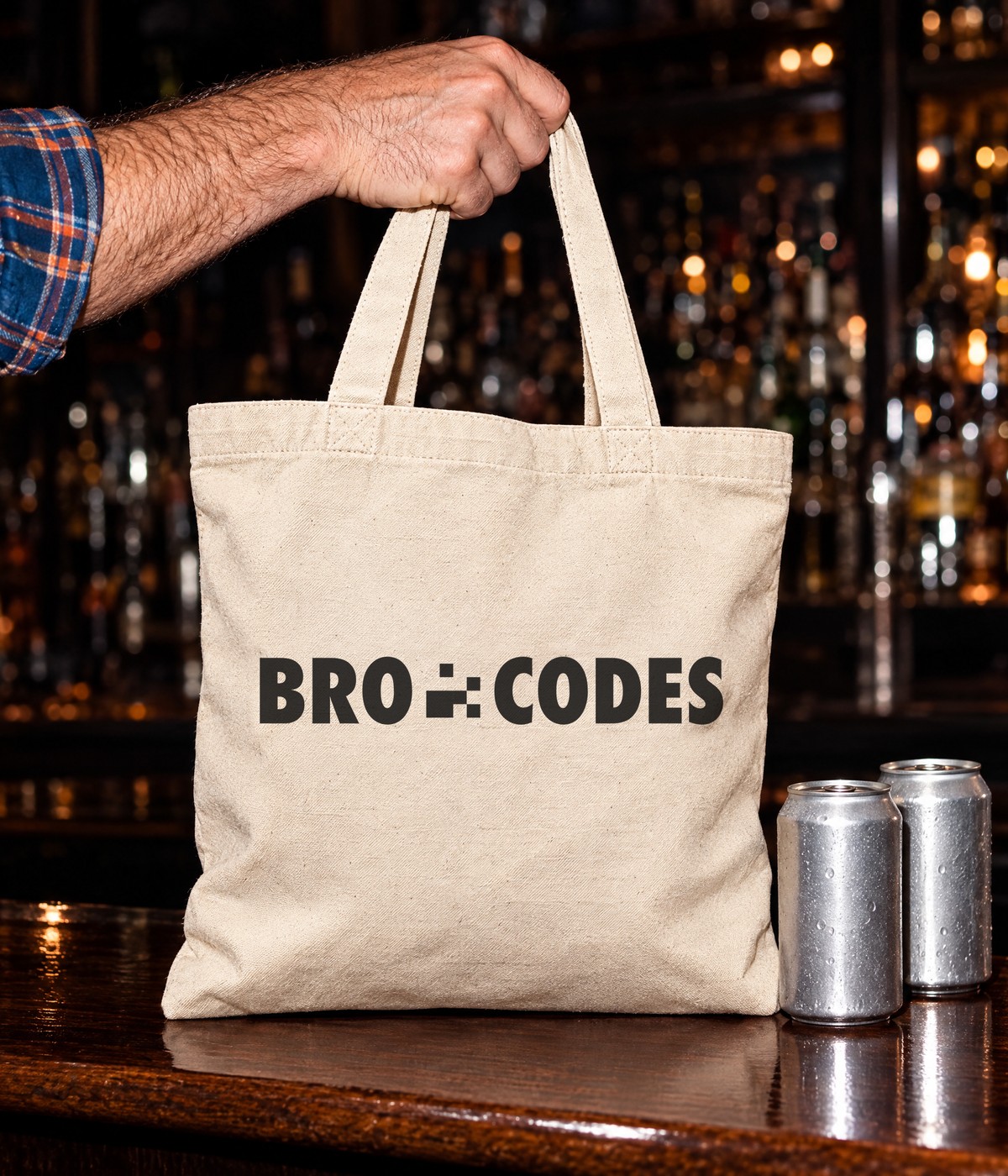 Bro Codes canvas tote set down on a bar next to two cans