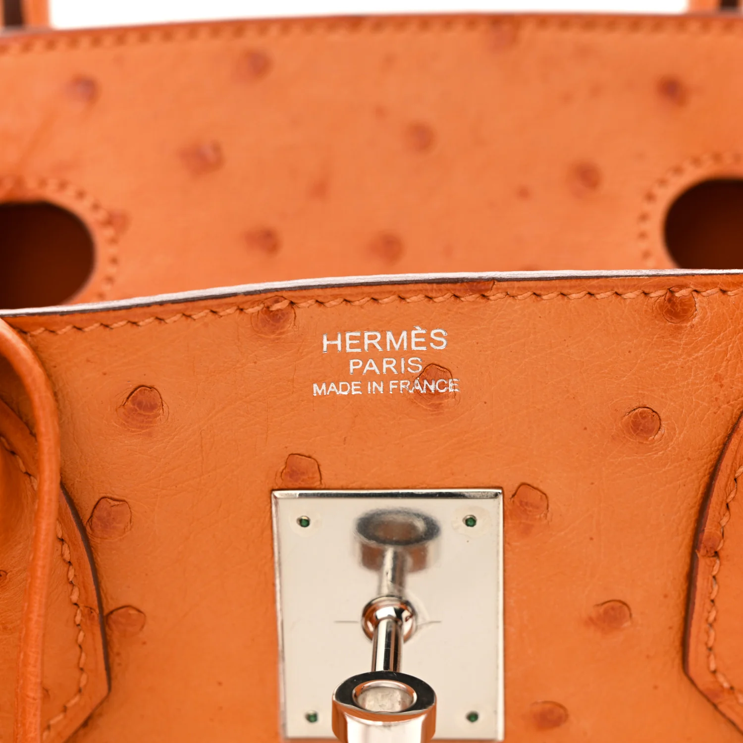 Nahaufnahme des Verschlusses der orangefarbenen Hermès Birkin