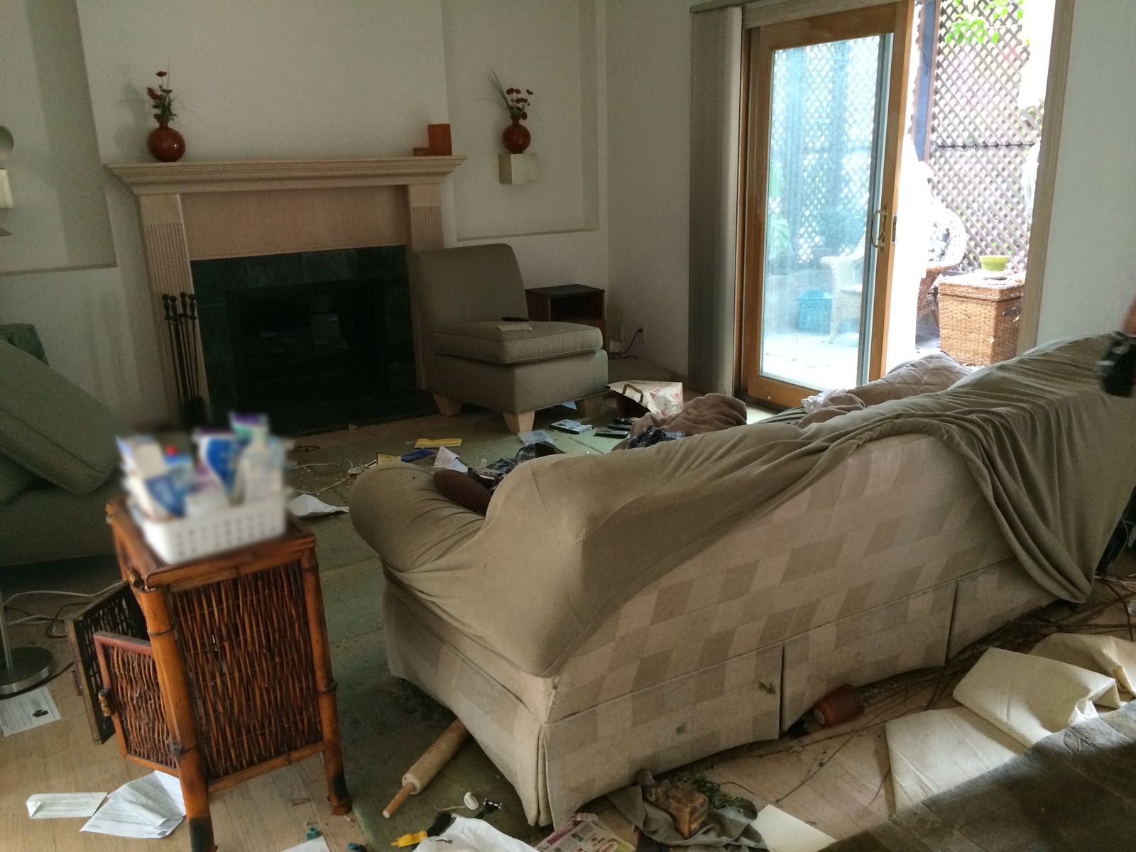 Living room of the inherited West Hollywood house before the cleanout: belongings and debris across the floor