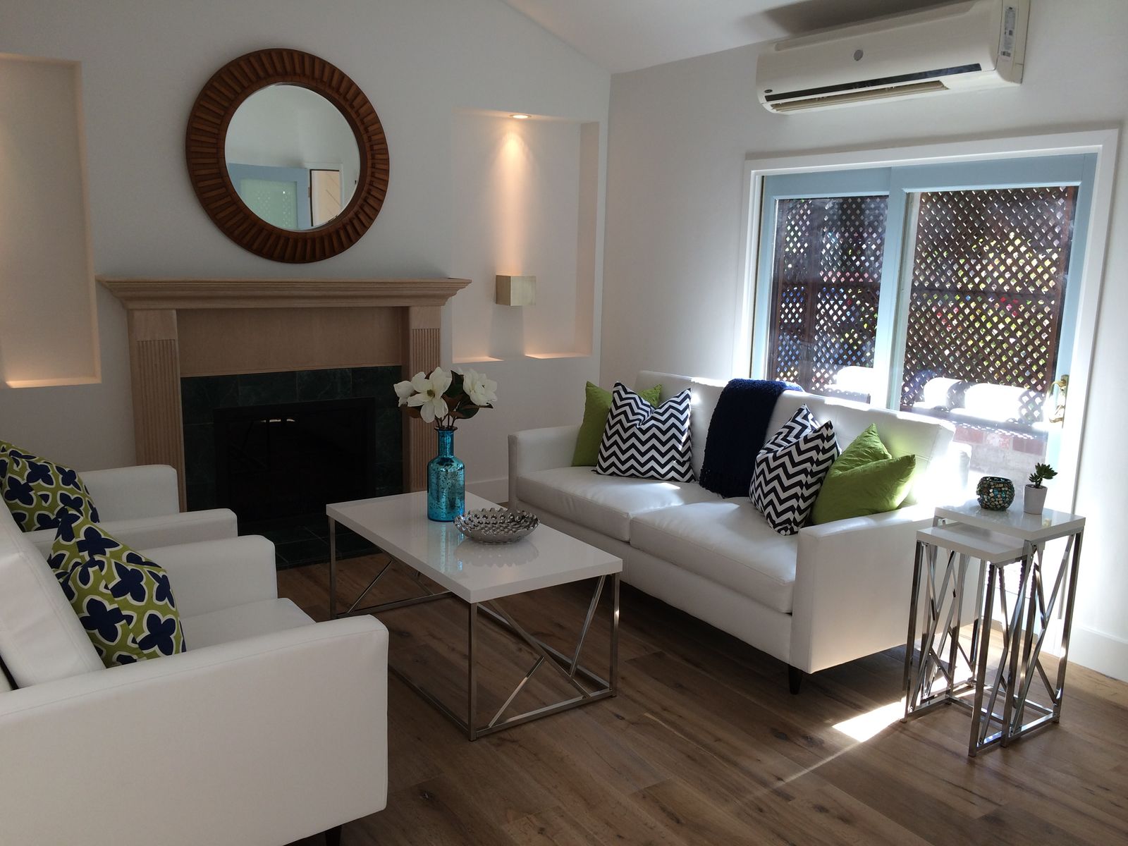 The same living room after the rehab, staged with white sofas for the sale