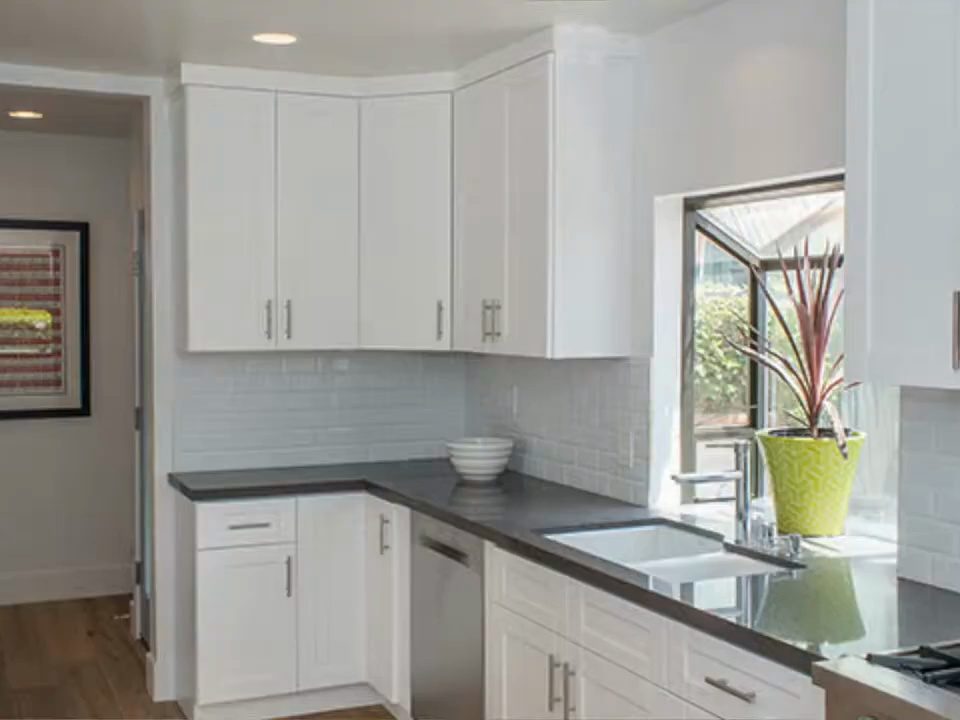 The same West Hollywood kitchen after the redesign, with white cabinets and new counters