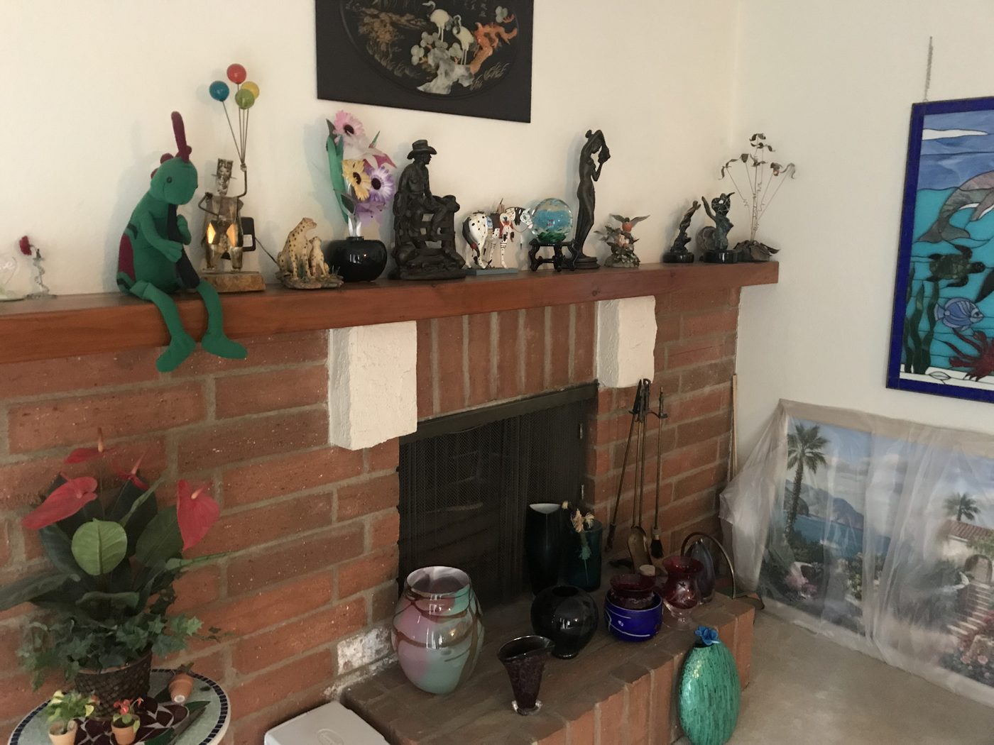 Chatsworth living room before: a lifetime of collectibles on the brick fireplace mantel