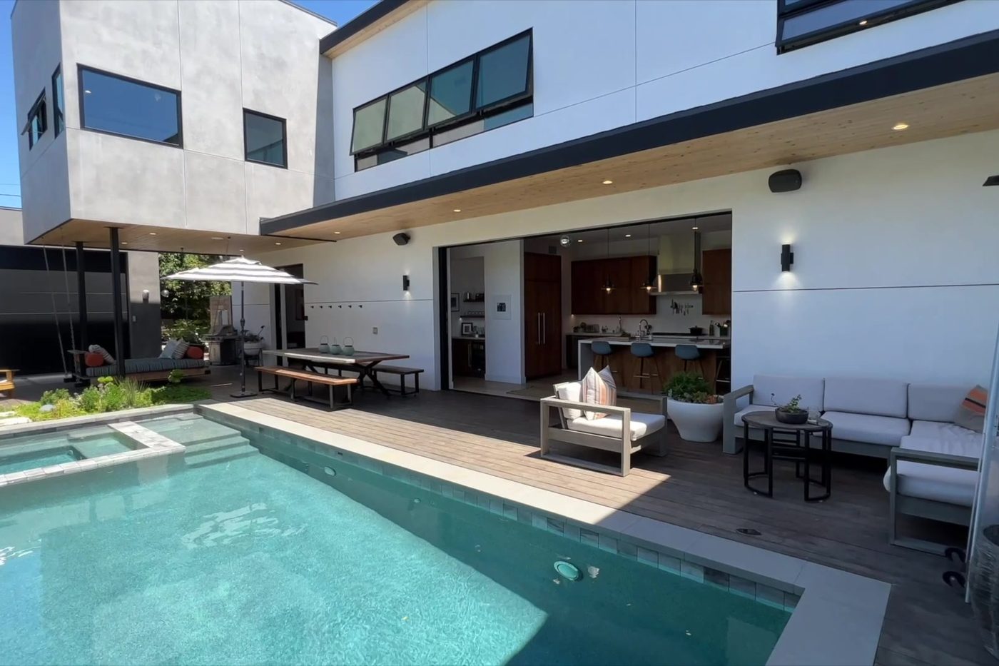 The Modern Monica finished: the back of the house with the pool, deck and kitchen doors open to the yard.
