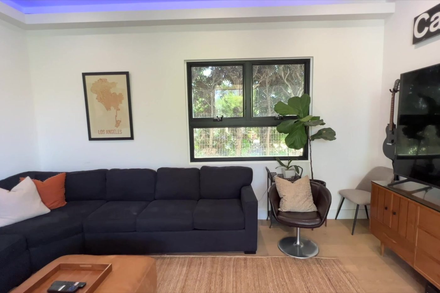The Modern Monica living room with a sectional sofa and a garden view.