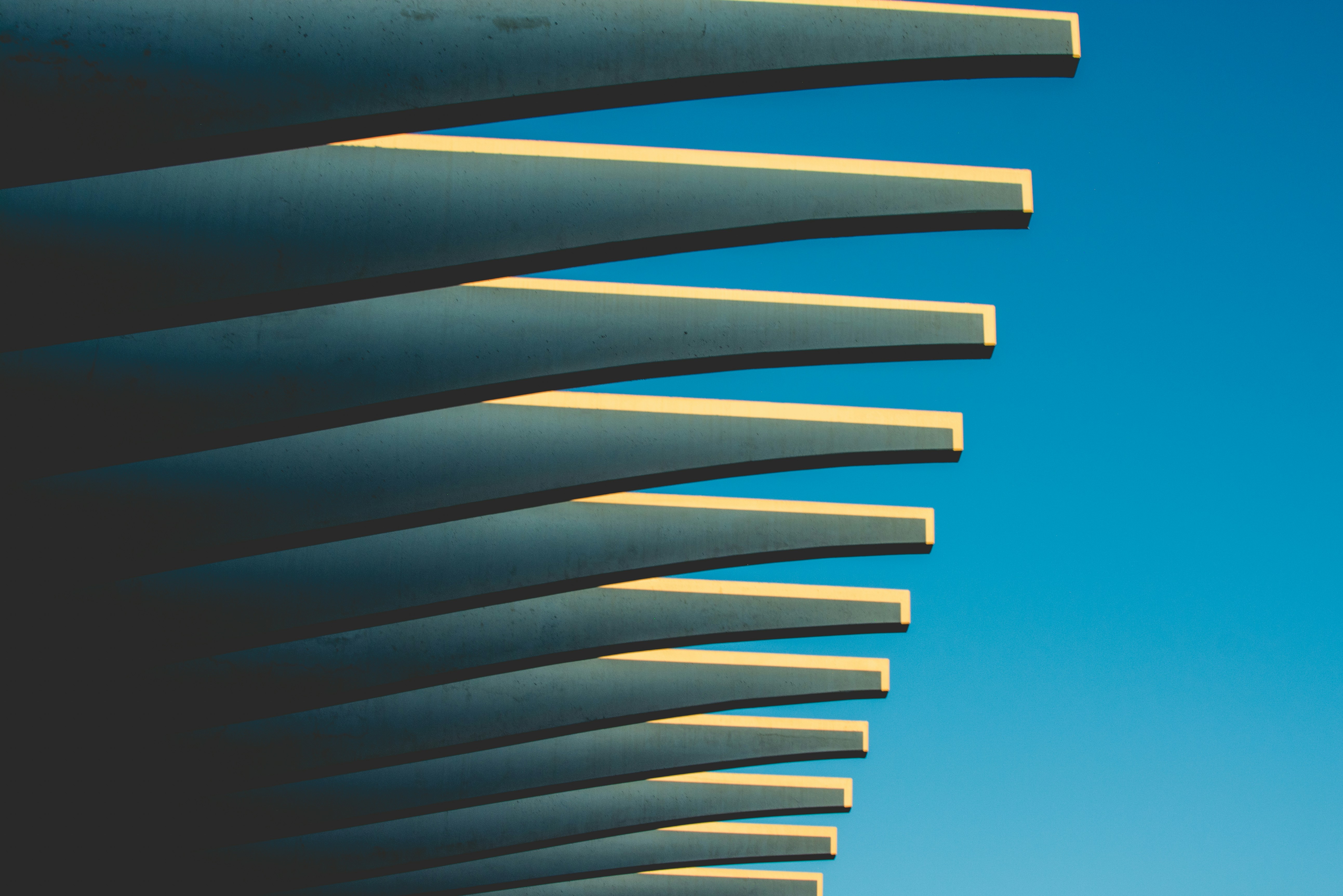 Curved concrete beams against a blue sky