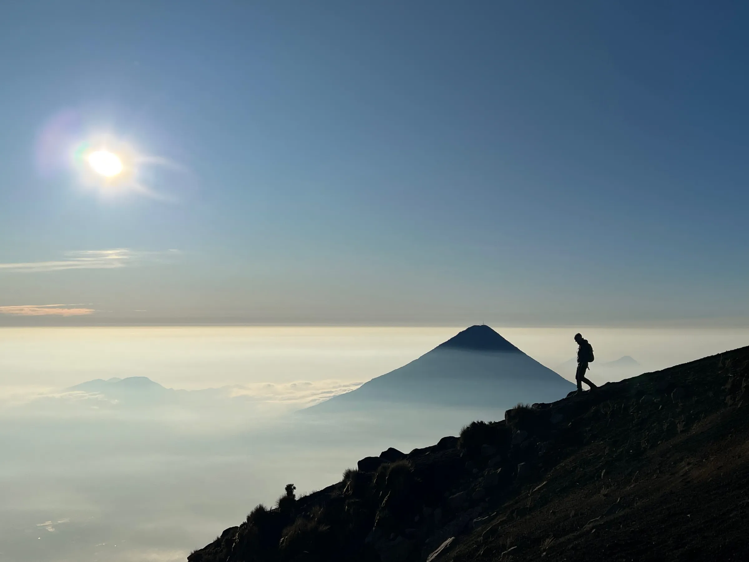 Hiker above the clouds on Acatenango Volcano in Guatemala