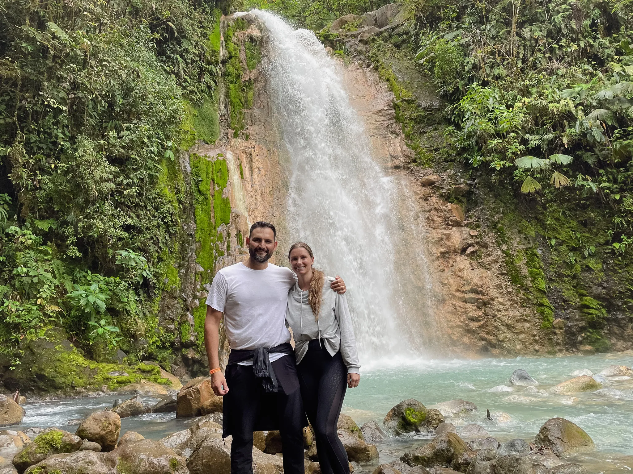 Adrienne and Alvaro beside a Costa Rican waterfall