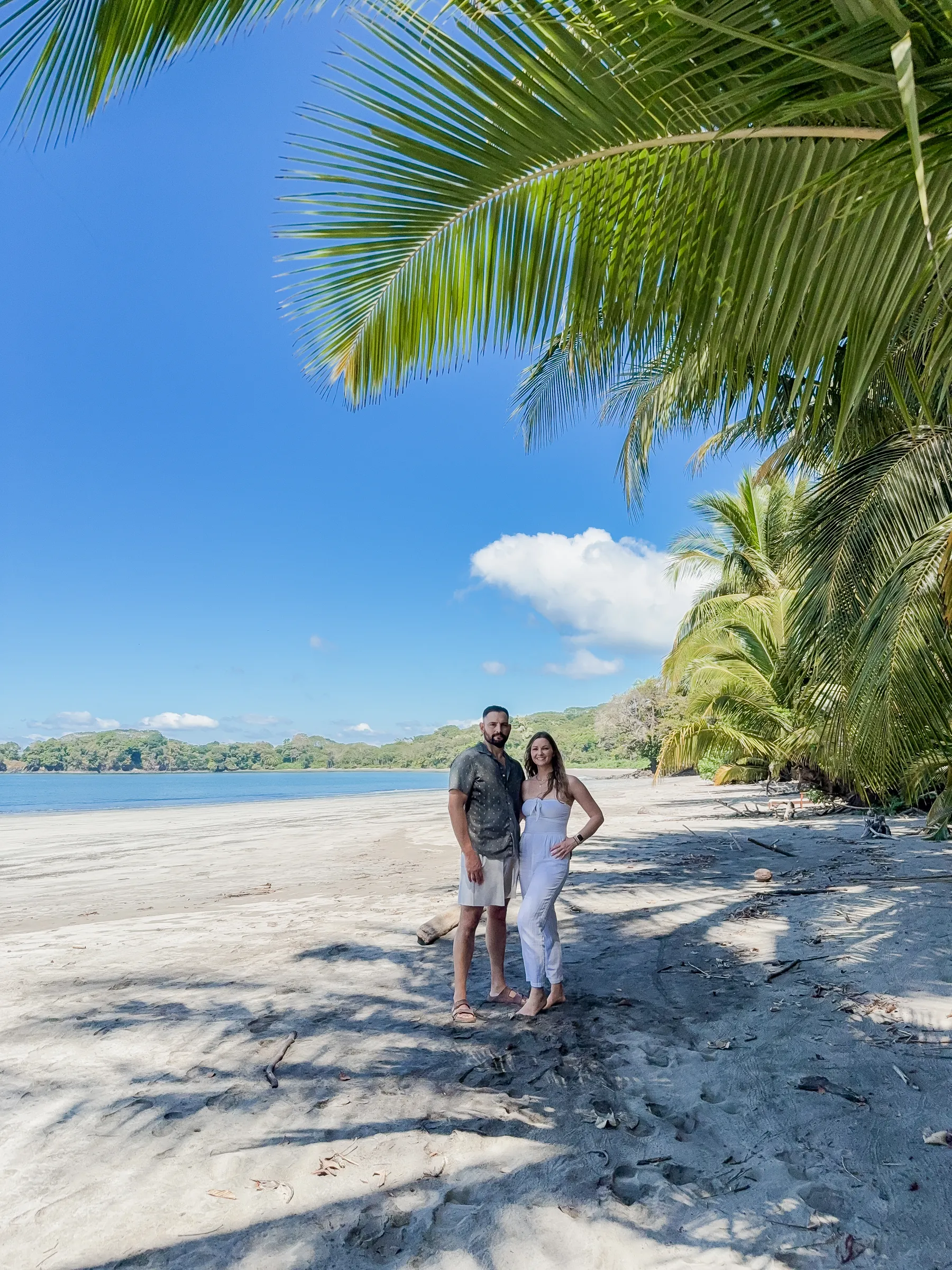 Osaviva founders Adrienne and Alvaro on a palm-lined beach in Costa Rica.