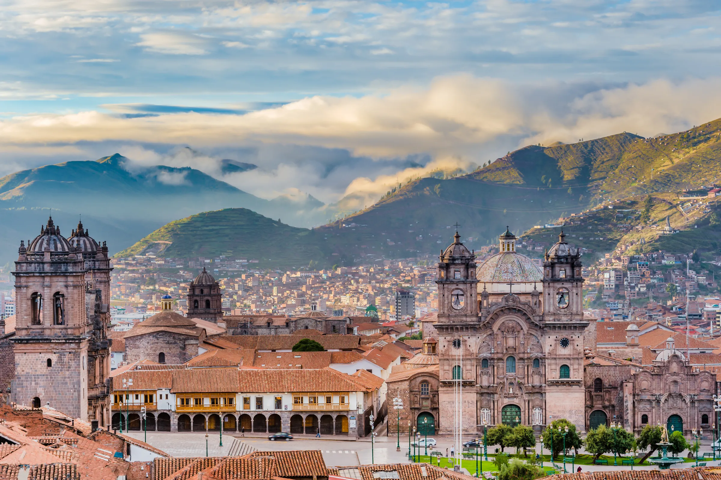 Cusco rooftops and church towers below distant mountains