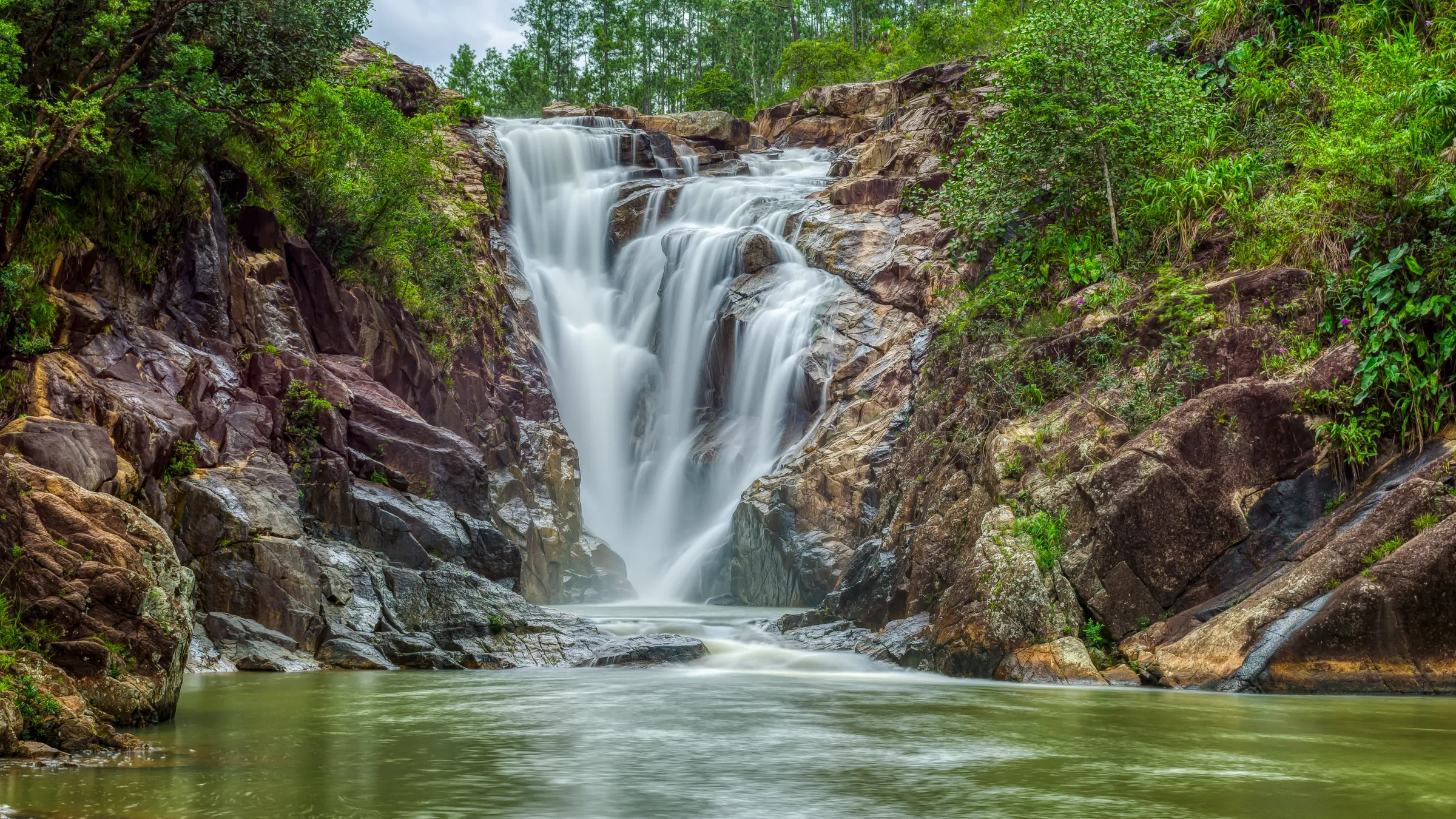 Waterfall cascading into a clear rocky pool