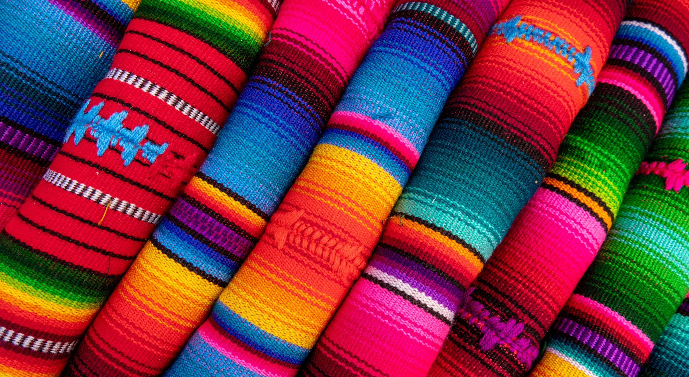 Brightly colored rolls of woven textiles