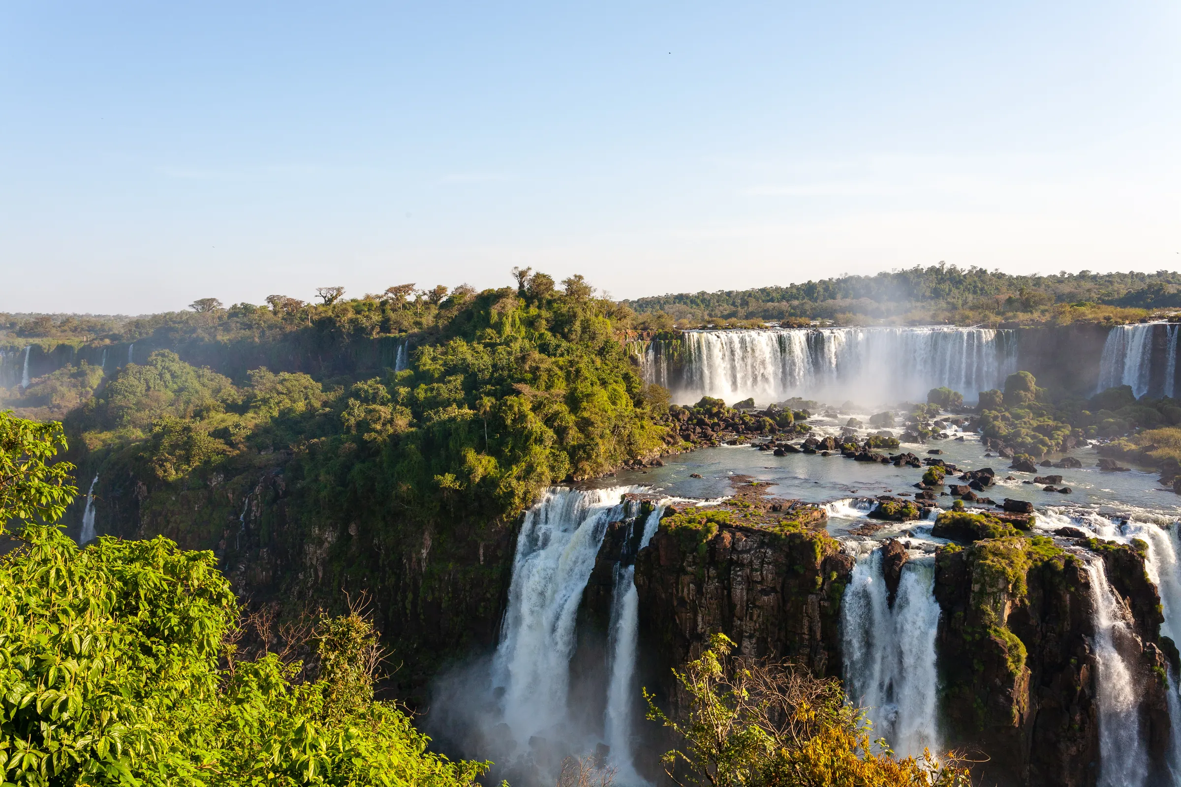 Broad waterfall cascades amid green forest
