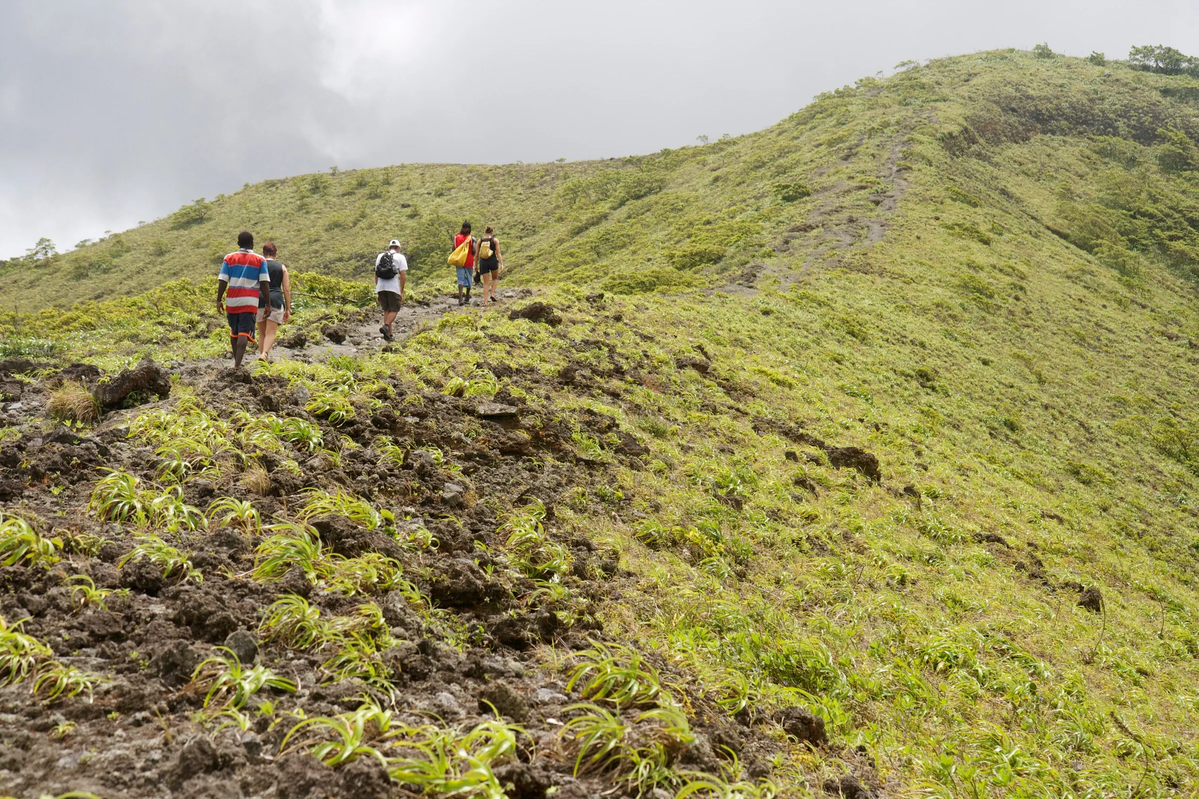 Hikers crossing a grassy mountain ridge