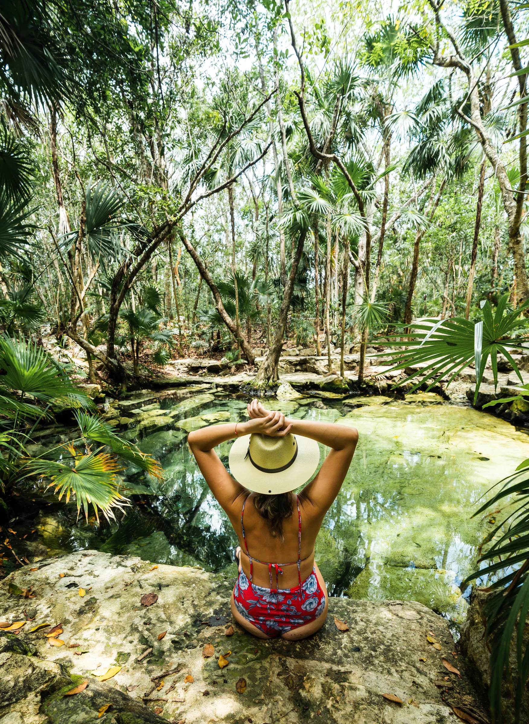 Visitor beneath a rainforest waterfall
