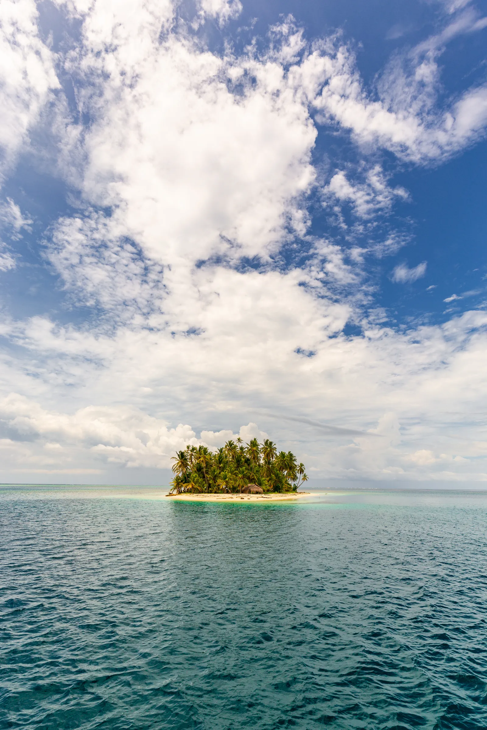 Small tropical island beneath towering clouds