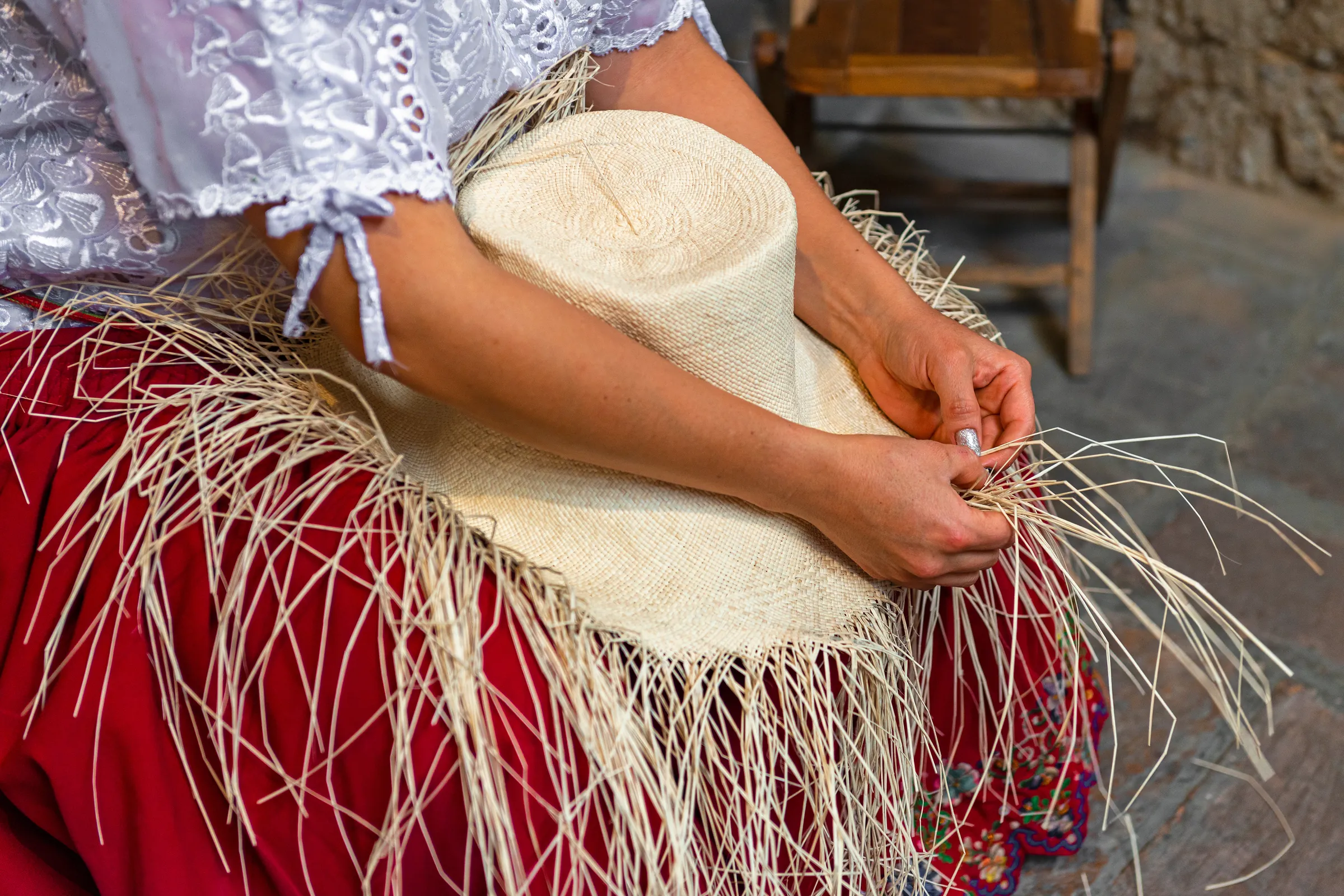 Artisan weaving a pale straw hat