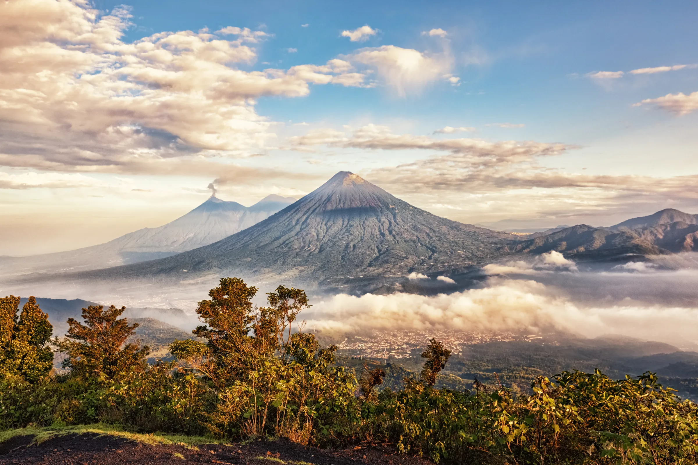 Volcano rising above clouds at sunrise