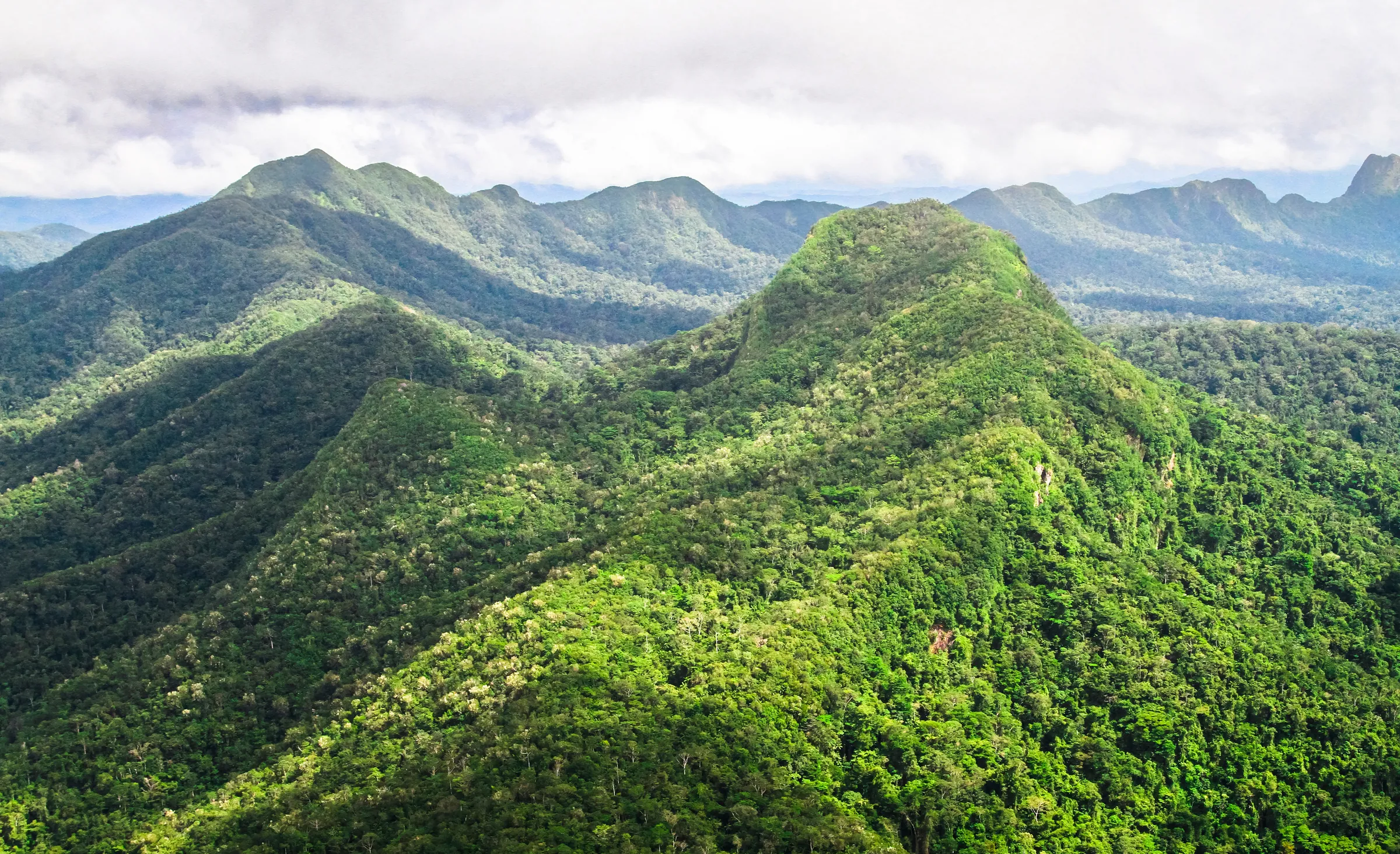 Green mountain ridges beneath cloudy skies