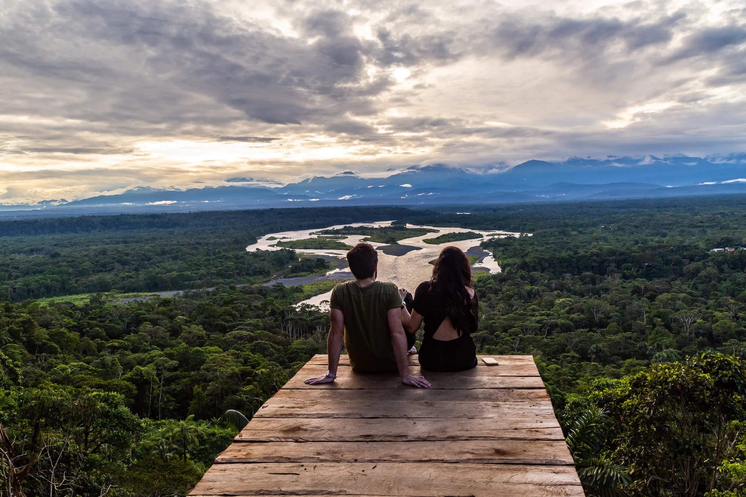 Couple overlooking a rainforest river from a wooden platform