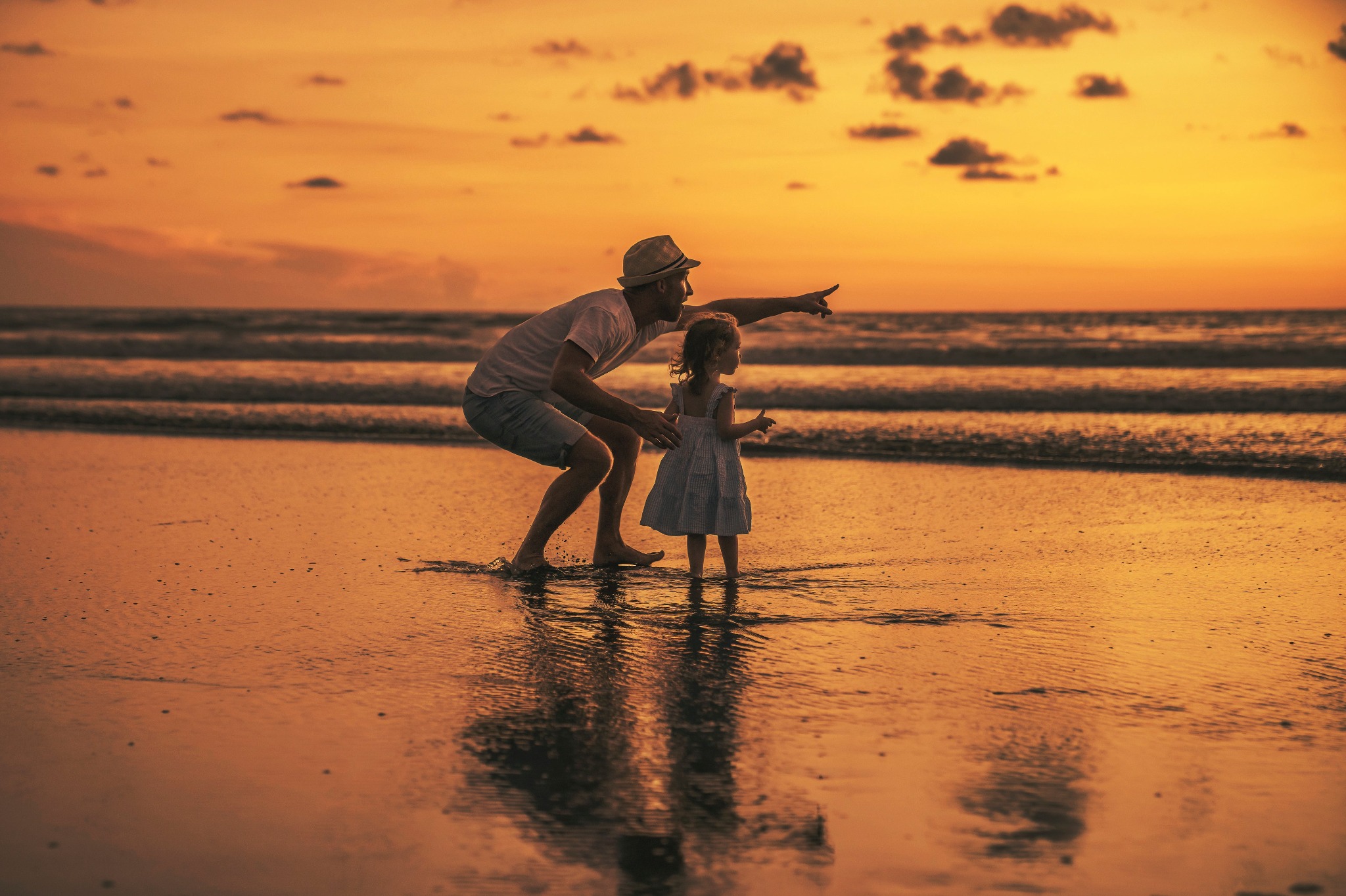 Father and daughter on a beach in Mexico at sunset