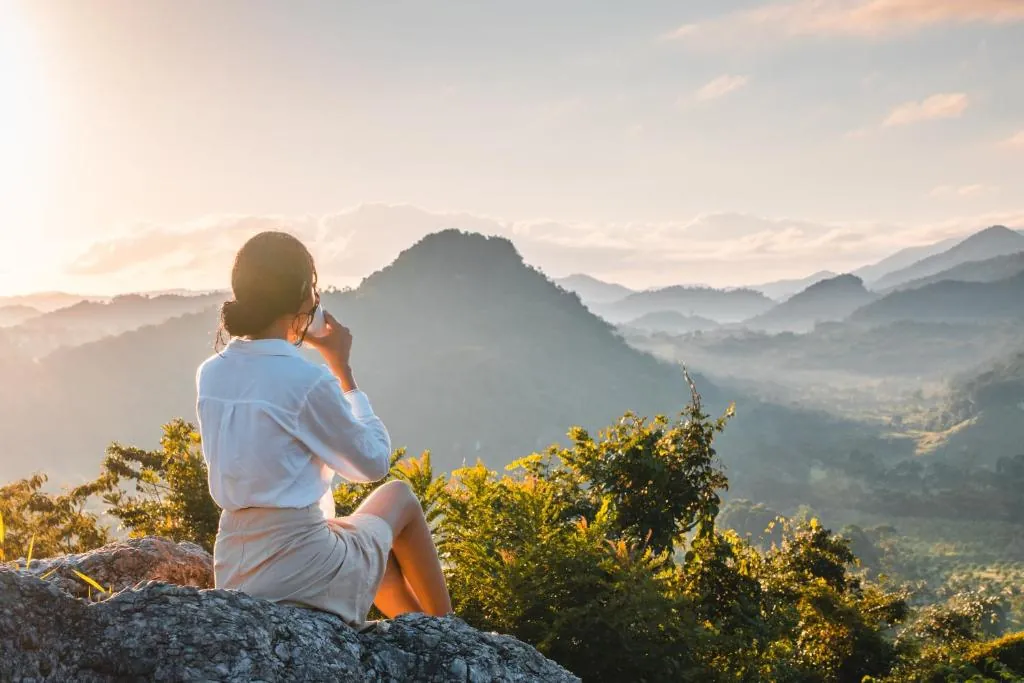 Traveler overlooking the forested mountains at Sleeping Giant in Belize.