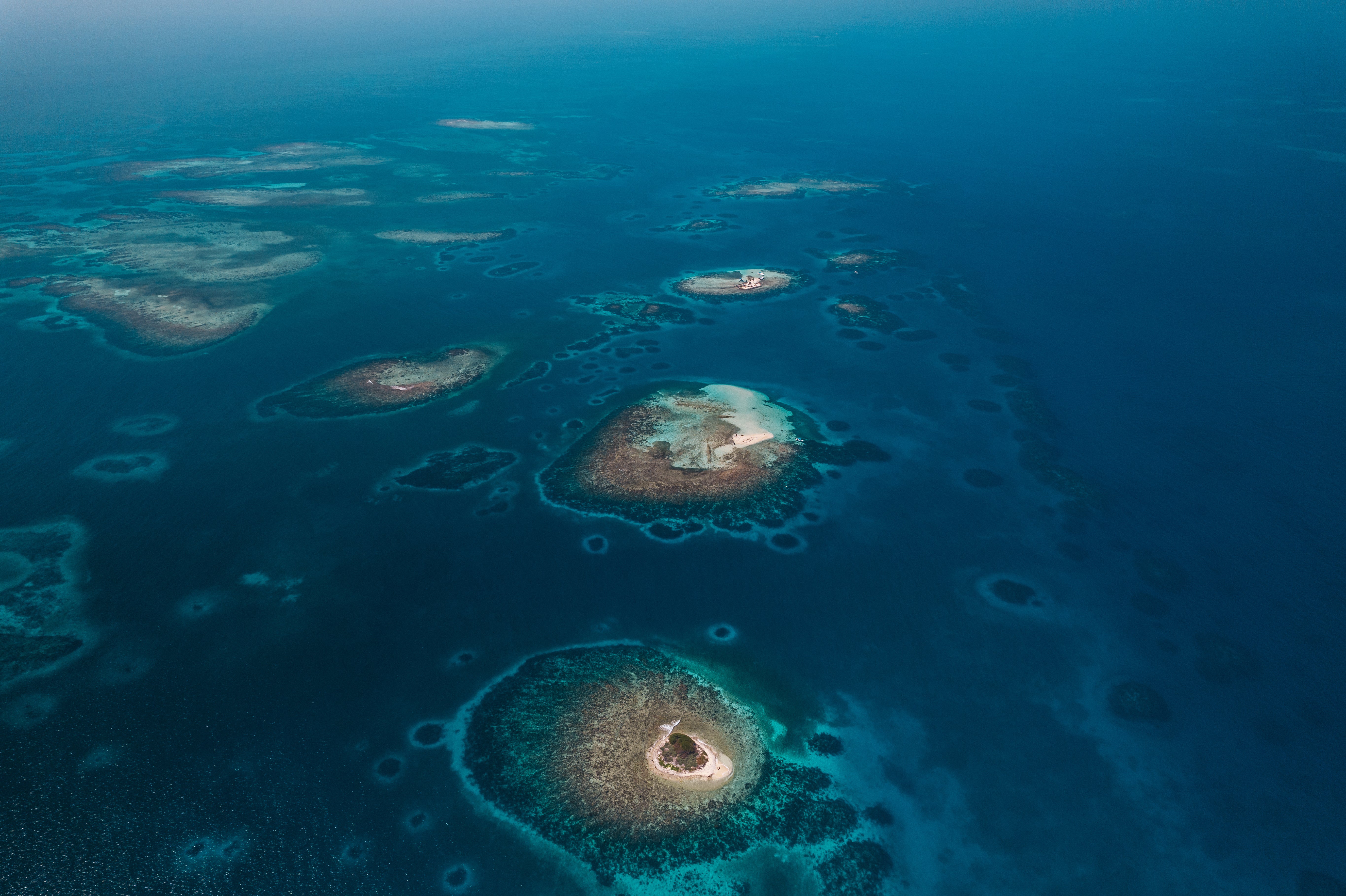 Wide aerial view of Belize’s small coral cayes and turquoise reef