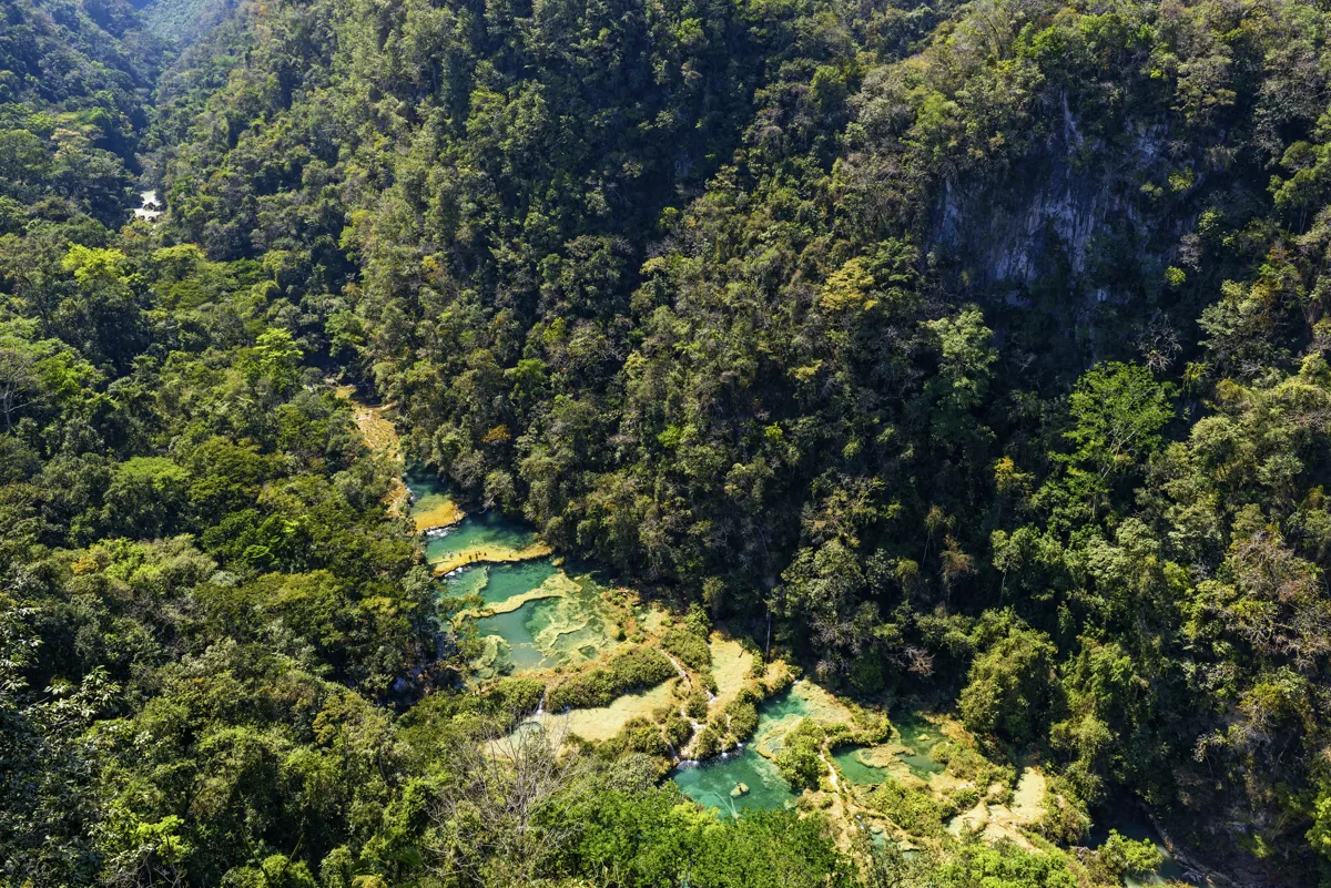 Turquoise river winding through a forested Guatemalan gorge.