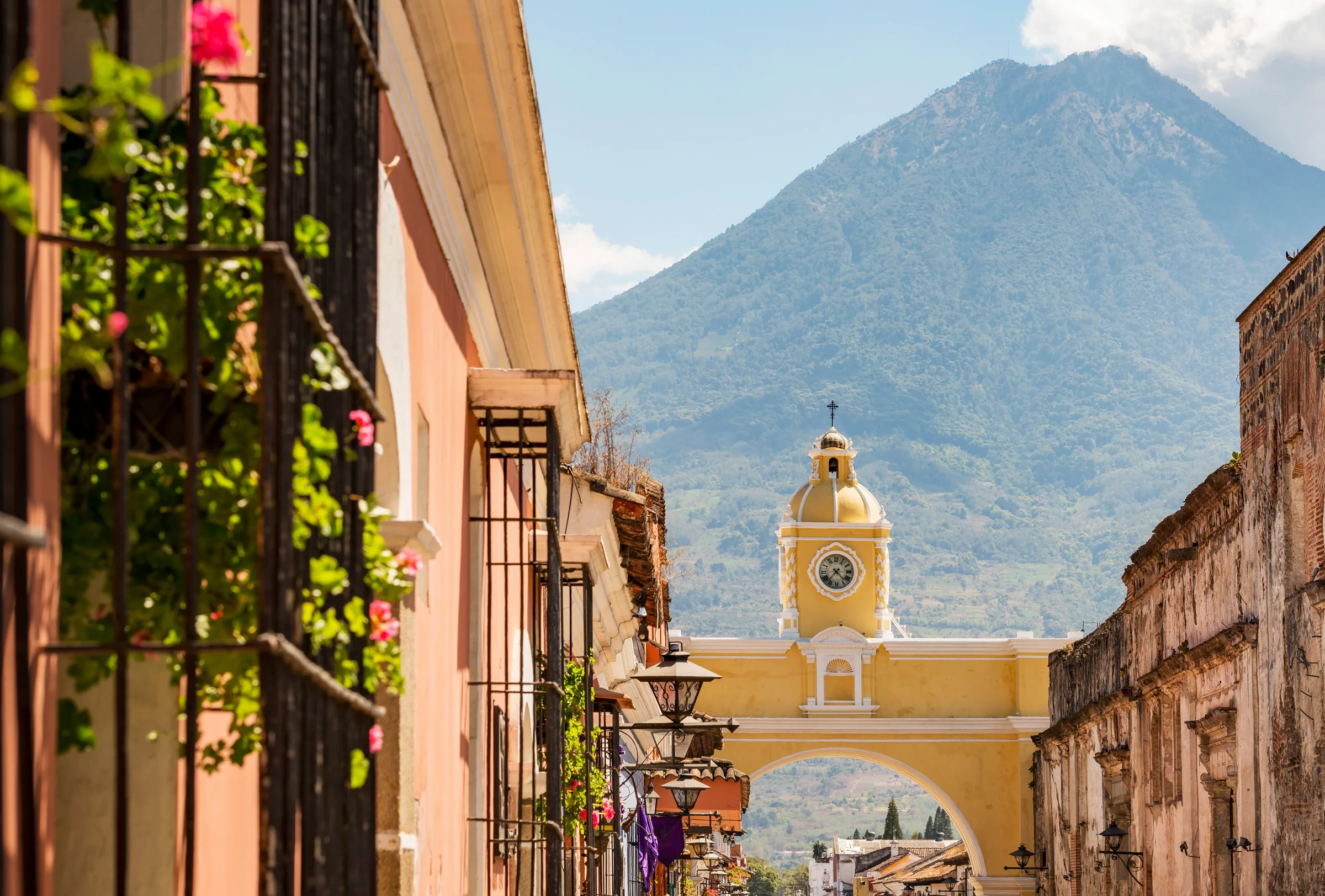 Antigua Guatemala's yellow arch with Volcán de Agua beyond.