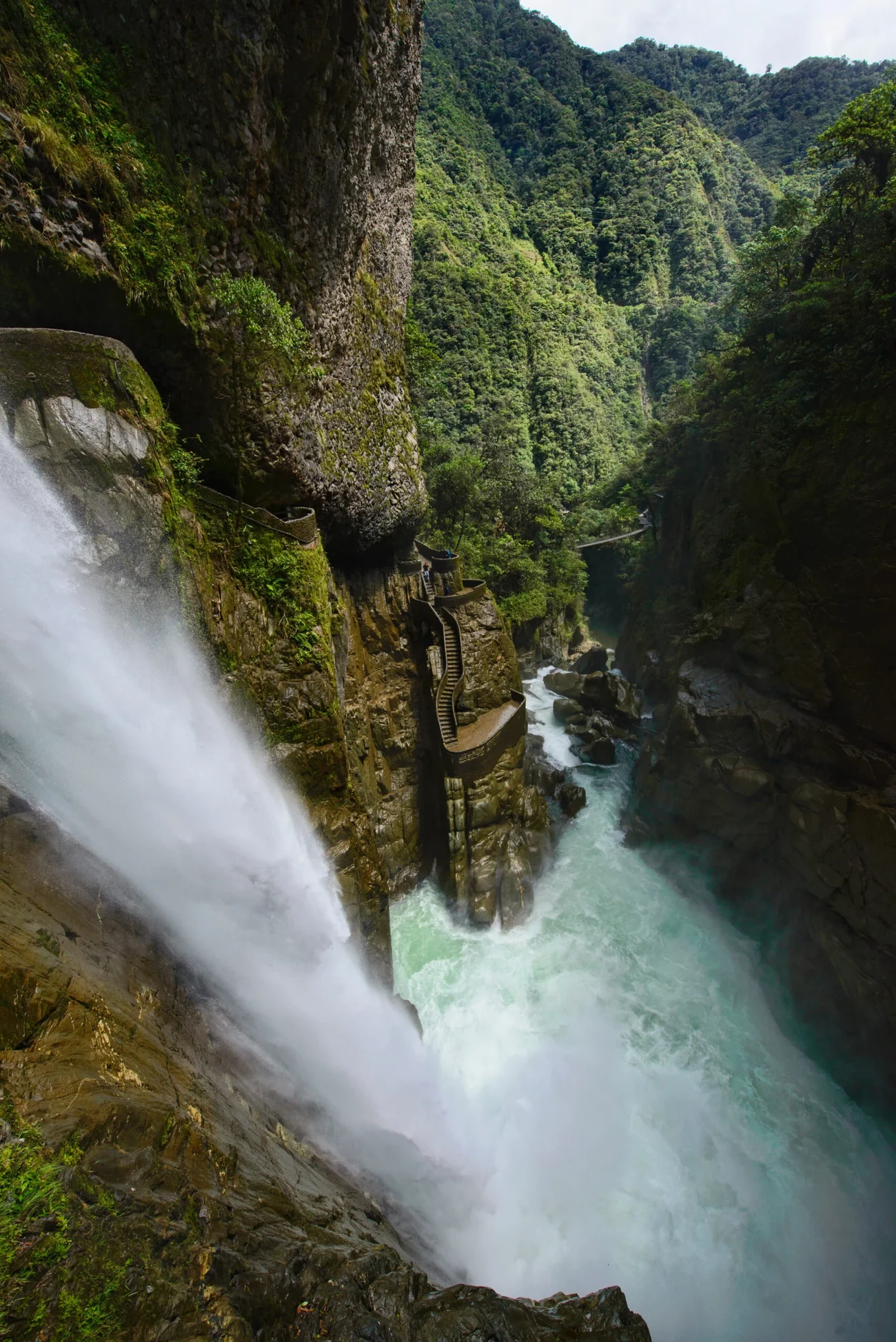 Waterfall dropping through a green gorge near Baños, Ecuador.