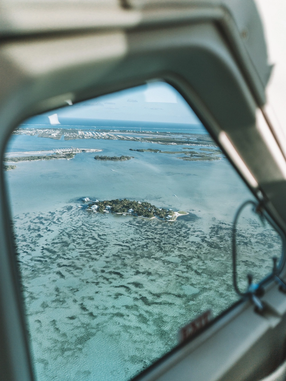 A small island resort seen through a small plane's window while flying over Belize's cayes.