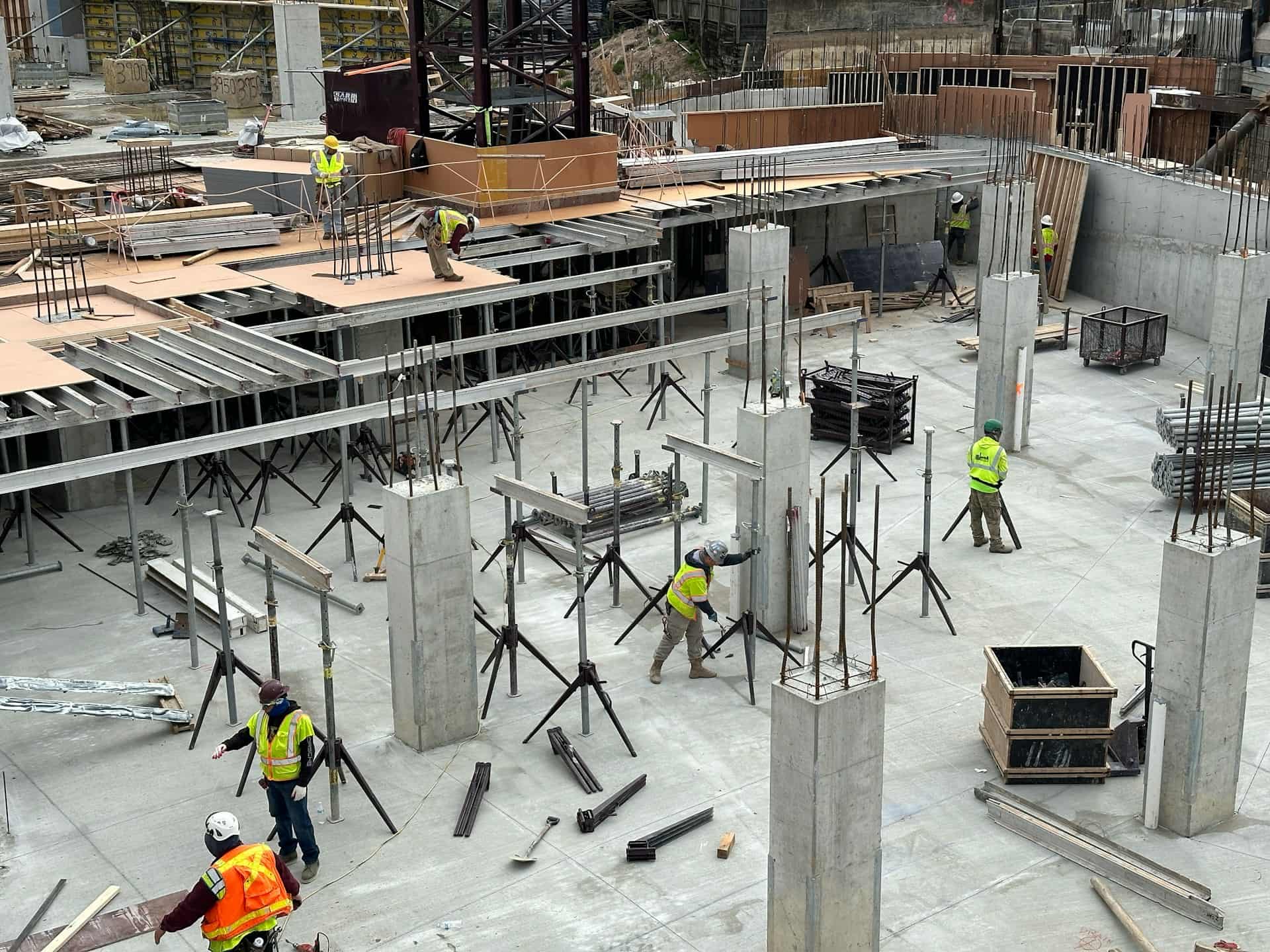 Concrete workers building columns on a structure.