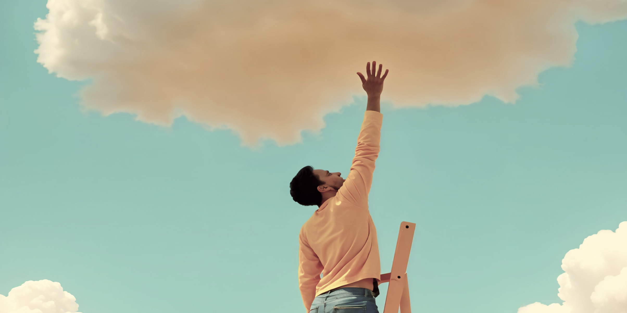 Man standing on a wooden ladder reaching up toward a large cloud against a clear blue sky.