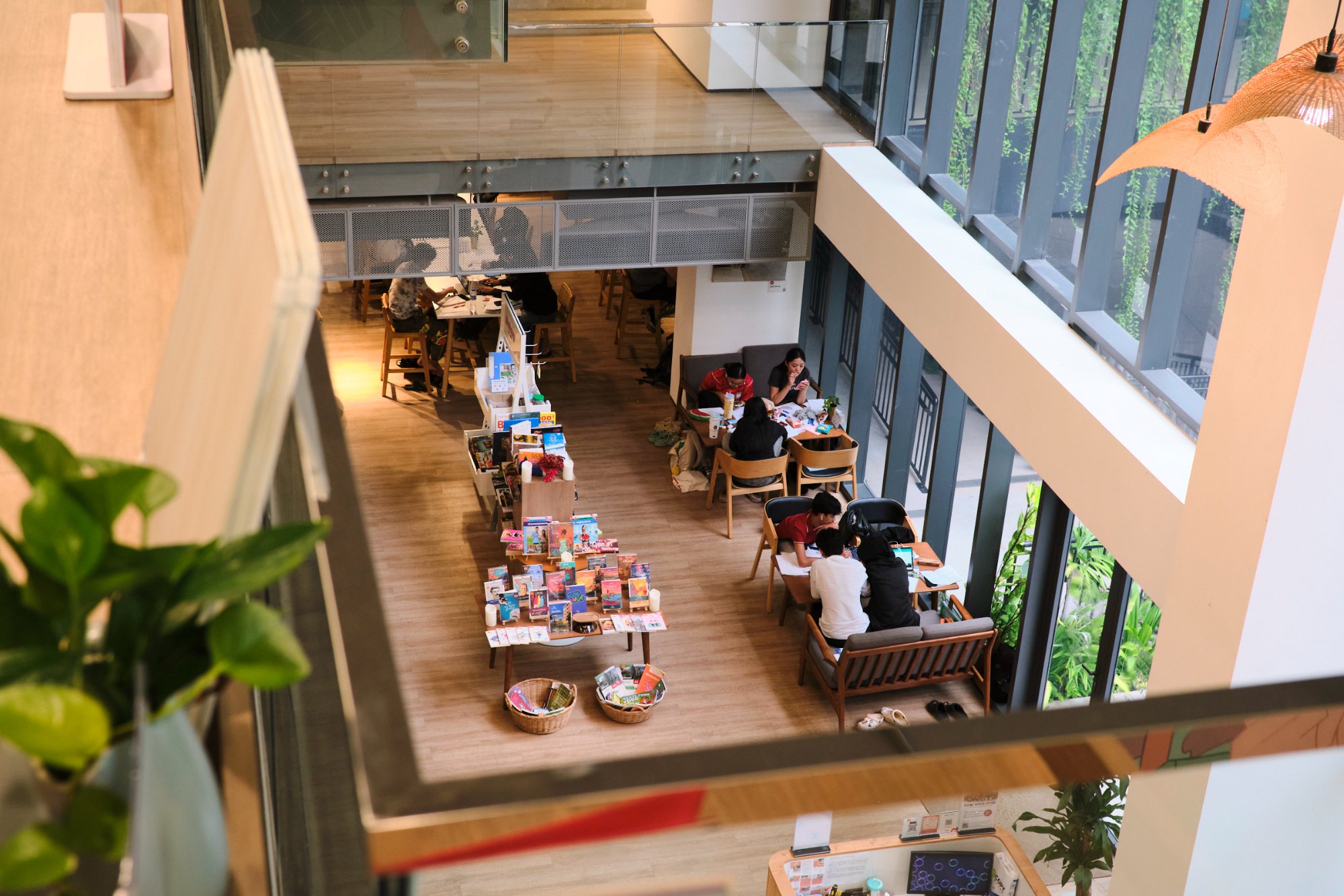 The Commune Work coworking floor from above, long shared tables and daylight